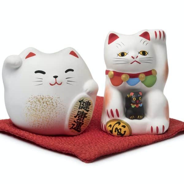 japanese maneki neko lucky cats on a red pillow