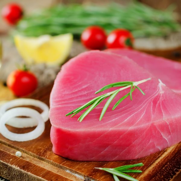 Tuna steak raw with lemon, rosemary, tomatoes and pepper